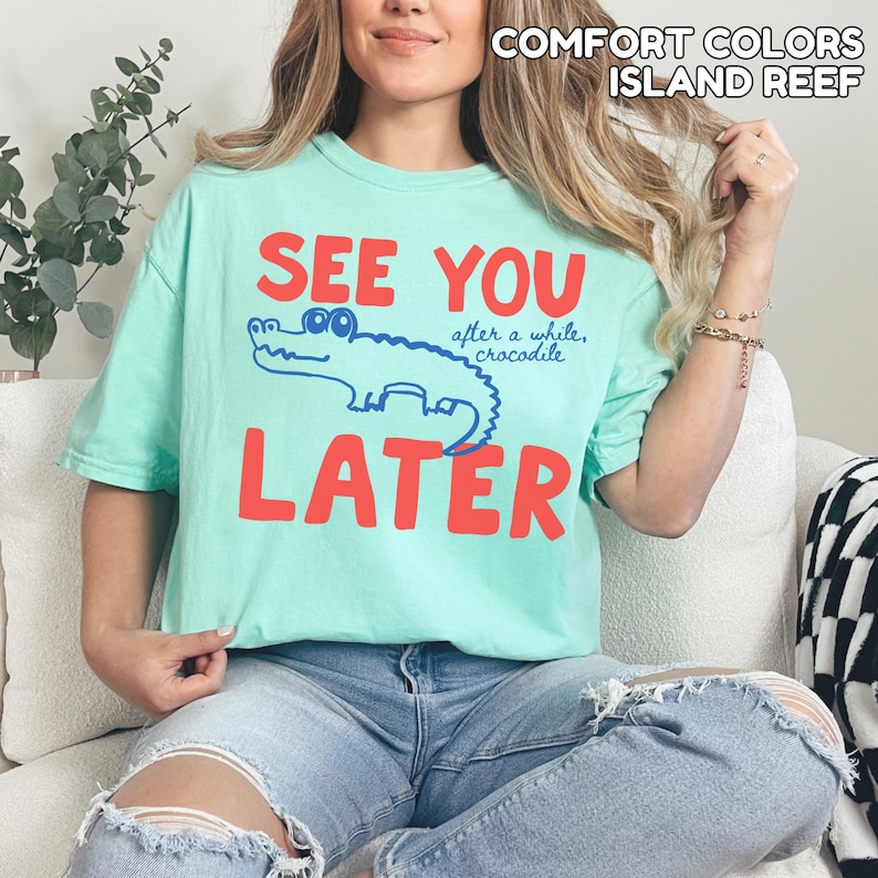 May include: A pale green t-shirt with the words "SEE YOU LATER" in red block letters. A blue cartoon crocodile is between the words. The text "after a while, crocodile" is above the crocodile.