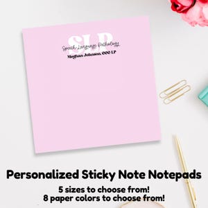 May include: Pink sticky note notepad with the text "Speech-Language Pathology" and "Meghan Johnson, CCC-SLP" in black text. The notepad is on a white surface with gold paper clips and a gold pen.