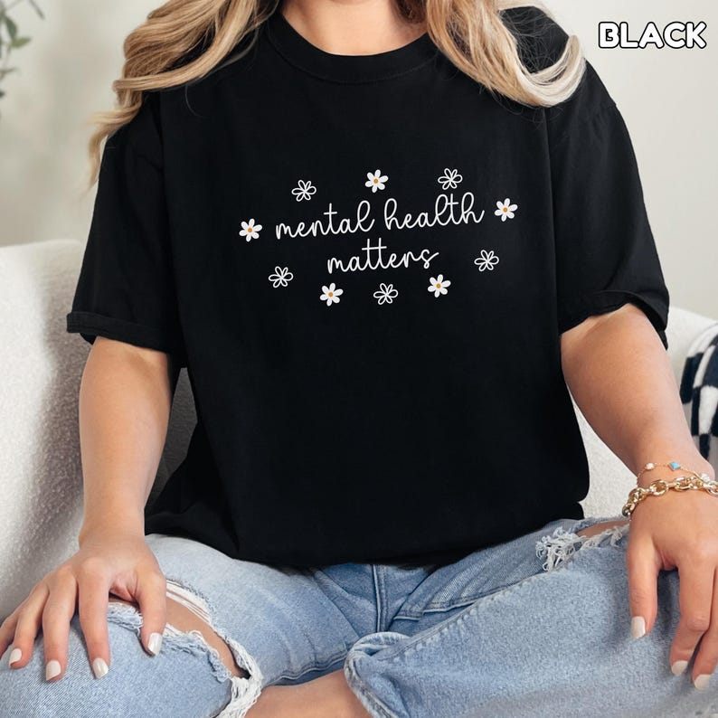 May include: Black t-shirt with the text "mental health matters" and small white flower graphics.