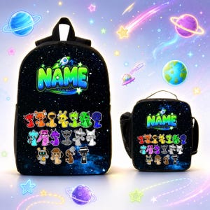 Op de afbeelding: Een zwarte rugzak en bijpassende lunchtas met een ruimte-sterrenstelselprint. Beide items tonen het woord NAME in felgroene letters boven een verzameling kleurrijke, gestileerde stripfiguren en een kleine afbeelding van een raket.