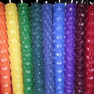 May include: A set of 12 honeycomb candles in various colors, including red, orange, yellow, green, blue, purple, and burgundy. The candles are arranged in a rainbow pattern.
