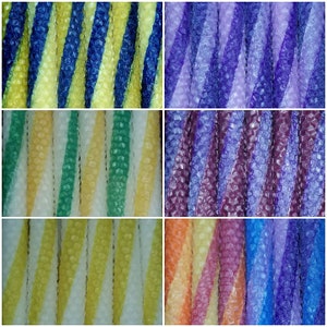 May include: A collage of eight different colored beeswax candles. The candles are all striped with two colors and have a honeycomb texture. The colors include yellow, blue, green, purple, orange, and white.