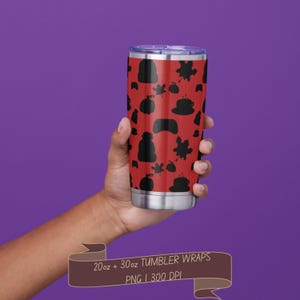以下が含まれることがあります： 赤色の背景に、ビーニー帽、カエデの葉、カボチャ、コーヒーカップの黒い模様が繰り返されるステンレス製タンブラー。バナーのテキストには「20oz + 30oz TUMBLER WRAPS PNG | 300 DPI」と記載されています。