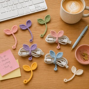 May include: A collection of handmade crochet leaf-shaped cable organizers in various pastel colors including pink, purple, green, yellow, blue, and cream. Some organizers are wrapped around white charging cables, while others are laid flat.