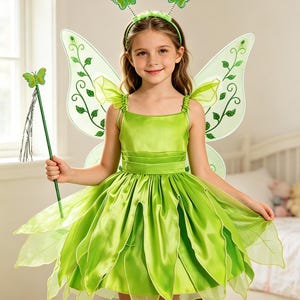 May include: A bright green fairy costume featuring a sleeveless satin dress with a layered petal skirt, sheer wings with vine patterns, a matching headband with two small butterfly antennae, and a green wand topped with a butterfly.