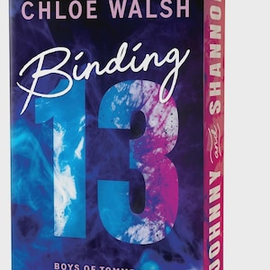 May include: A paperback book titled Binding 13 by Chloe Walsh, featuring a dark blue and purple smoke-like background. The large number 13 is printed in the center, and the spine displays the text Johnny and Shannon in white lettering.