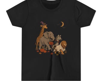 May include: A black short-sleeve t-shirt featuring a graphic illustration of a giraffe in a purple witch hat, an elephant holding a jack-o'-lantern, a zebra, and a lion wearing a ghost costume, surrounded by orange pumpkins and autumn leaves.