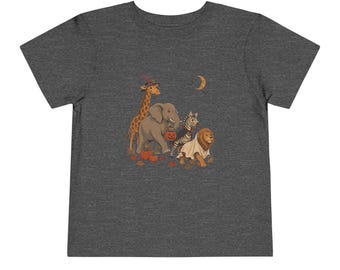 May include: A dark heather gray t-shirt featuring a graphic illustration of a giraffe, elephant, zebra, and lion dressed in Halloween costumes. The animals are surrounded by small pumpkins and autumn leaves under a crescent moon in the night sky.