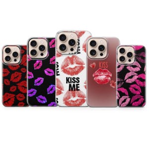 Könnte beinhalten: Fünf Smartphone-Hüllen mit Lippenabdruck-Motiven. Die erste ist schwarz mit roten Lippen, die zweite schwarz mit violetten Lippen, die dritte weiß mit roten Lippen und dem Text KISS ME, die vierte transparent mit rotem Lippenabdruck und dem Text KISS, die fünfte schwarz mit pinken Lippen.