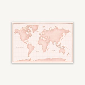 May include: A rectangular world map print in shades of soft blush pink. The continents are rendered in a solid light pink tone against a lighter pink background with a grid overlay. The text Pacific Ocean, Atlantic Ocean, and Indian Ocean is visible.