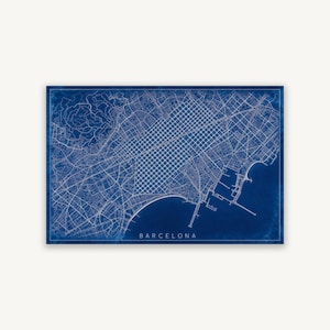May include: A rectangular map print of Barcelona featuring a deep blue background with white lines representing the city street grid, coastline, and harbour. The word BARCELONA is printed in white capital letters at the bottom centre of the map.