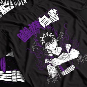 Pode incluir: Uma t-shirt preta com uma estampa gráfica de um personagem de anime de cabelo espetado segurando uma espada. O personagem está rodeado por efeitos de energia roxos e texto japonês. O design inclui linhas brancas e roxas.