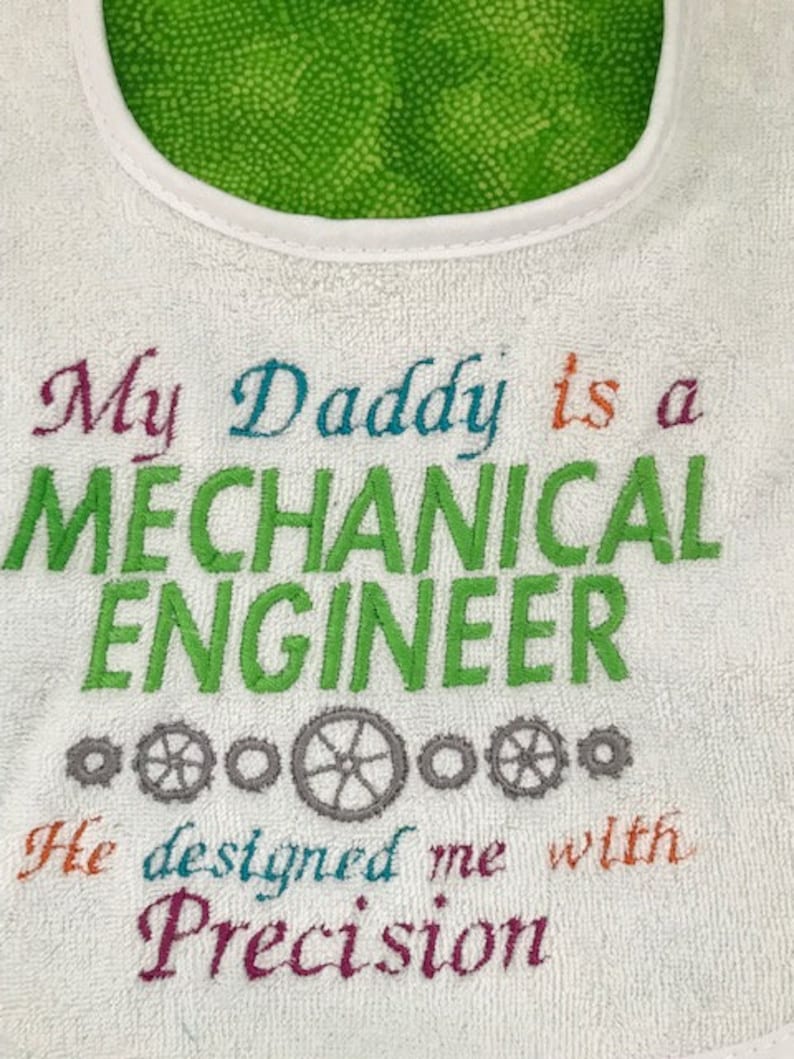 Puede incluir: Babero blanco para beb&eacute; con texto bordado de colores que dice "Mi pap&aacute; es un INGENIERO MEC&Aacute;NICO Me dise&ntilde;&oacute; con precisi&oacute;n".