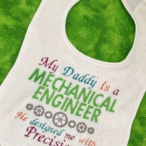 Puede incluir: Babero blanco para beb&eacute; con texto bordado de colores que dice "Mi pap&aacute; es un ingeniero mec&aacute;nico. Me dise&ntilde;&oacute; con precisi&oacute;n."