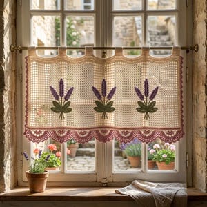 Può includere: Una tenda da caffè all'uncinetto color crema con motivo a griglia e tre rametti di lavanda ricamati con fiori viola e foglie verdi. La tenda presenta un bordo inferiore smerlato color rosa antico ed è appesa a un'asta in ottone.