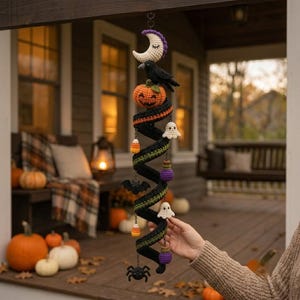 May include: A spiral crochet Halloween hanging decoration featuring a white crescent moon, a black crow, an orange pumpkin, white ghosts, candy corn, black bats, purple potion bottles, and a black spider, all suspended from a central black coil.