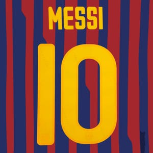 May include: A sports jersey featuring vertical red and blue stripes. The name MESSI is printed in bold yellow capital letters above the number 10, which is also rendered in a large, bold yellow font centered on the fabric of the garment.