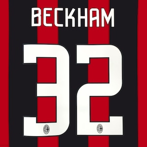 May include: A sports jersey featuring vertical red and black stripes. The back displays the name BECKHAM in white capital letters above the large white number 32. Each digit of the number 32 contains a small circular AC Milan team logo at the base.