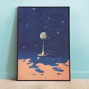 May include: A rectangular framed wall art print featuring a dark blue starry night sky above a peach-colored surface. A central blue sphere with the gold text ELO sits above a white liquid splash, with blue liquid droplets pooling on the peach base.