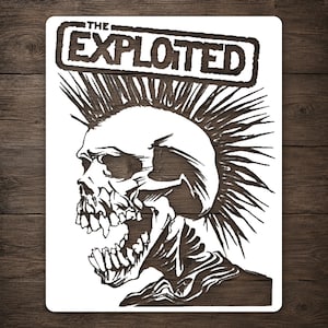 May include: A rectangular white sign featuring a black graphic illustration of a skull with a large mohawk hairstyle. Above the skull, the text THE EXPLOITED is printed in a bold, blocky font. The design is presented on a flat, solid surface.