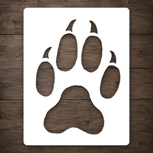 May include: A rectangular white stencil featuring a large, centered cutout of an animal paw print. The design includes a prominent central pad and four distinct toe pads, each topped with a sharp, curved claw mark, creating a clear silhouette.
