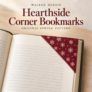 Peut inclure: Un marque-page d'angle triangulaire en tissu rouge foncé avec un motif de flocons de neige blancs, placé sur le coin supérieur d'une page de livre ouverte. Le texte WALKER DESIGN Hearthside Corner Bookmarks ORIGINAL SEWING PATTERN est visible.