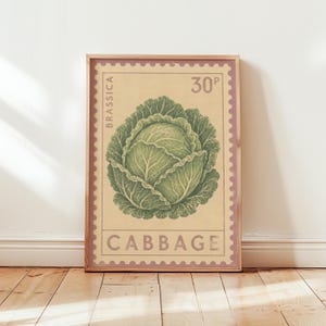 Op de afbeelding: Een rechthoekige wandkunstprint met een vintage postzegelontwerp met een geschulpte rand. Het midden toont een gedetailleerde illustratie van een groene kool op een crèmekleurige achtergrond. Tekst bevat BRASSICA, 30P en CABBAGE in schreeflettertype.