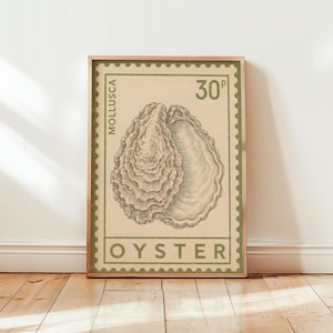 Könnte beinhalten: Ein rechteckiger Wandkunstdruck im Design einer Vintage-Briefmarke mit einer detaillierten Illustration einer Austernschale in der Mitte. Der Druck enthält den Text MOLLUSCA, 30P und OYSTER in gedämpftem Olivgrün auf cremefarbenem Hintergrund.