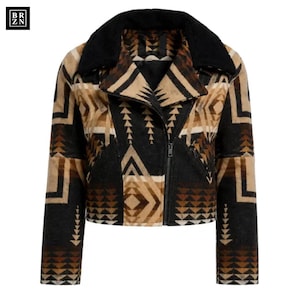 May include: A cropped jacket featuring a black, tan, and brown geometric pattern with a black faux fur collar. The jacket has a diagonal front zipper closure, long sleeves, and two zippered pockets on the front. The BRZN logo is in the top left corner.