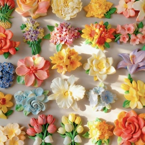 Pode incluir: Uma coleção de vários ornamentos florais tridimensionais com uma ampla gama de cores, incluindo rosa, amarelo, laranja, azul e roxo. Cada peça retrata diferentes tipos de flores, como rosas, tulipas e lírios.