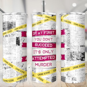 May include: A white tumbler with a newspaper print design and yellow "Crime Scene" tape. The tumbler has a pink stripe with the text "If at first you don't succeed, it's only attempted murder."