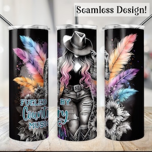 Op de afbeelding: Een zwarte en witte tumbler met een aquarelontwerp van veren en zonnebloemen. De tumbler heeft de tekst "Fueled by Country Music" aan de voorkant.