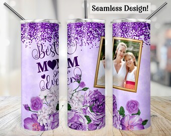 May include: A purple tumbler with a floral design and the words "Best Mom Ever." The tumbler features a photo in a gold frame and a seamless design. The design includes purple flowers and glitter.