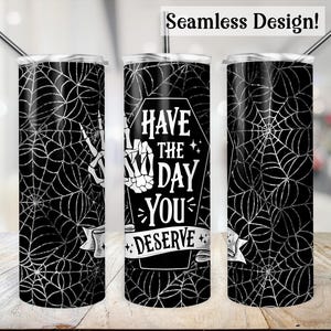 May include: A black and white tumbler with a spiderweb pattern and the text "Have the day you deserve".