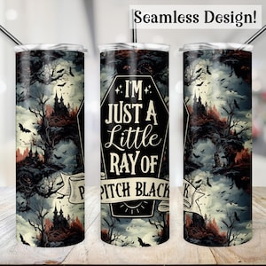 May include: A black and white tumbler with a spooky forest scene and the text "I'm just a little ray of pitch black" in a coffin shape. The tumbler is designed for hot or cold beverages.