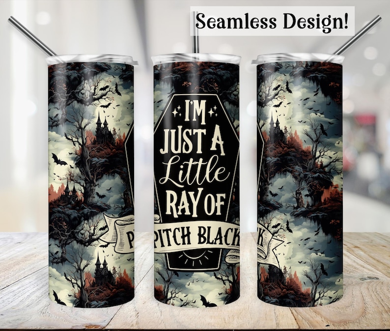 May include: A black and white tumbler with a spooky forest scene and the text "I'm just a little ray of pitch black" in a coffin shape. The tumbler is designed for hot or cold beverages.
