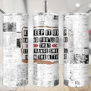 May include: A white tumbler with a newspaper print design. The text "KEEP IT UP AND YOU'LL BE THAT STRANGE SMELL IN THE ATTIC" is printed on the tumbler.