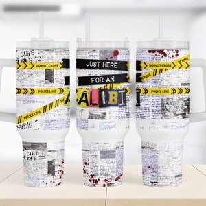 Op de afbeelding: Drie witte roestvrijstalen bekers met een krantenprintontwerp en geel en zwart politielint met de tekst "DO NOT CROSS", "JUST HERE FOR AN ALIBI" en "DO NOT CROSS" erop gedrukt.
