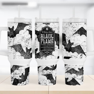 May include: Three white travel mugs with black bat silhouettes and a distressed white background. The center mug has a black label with the text "The Black Salem Candle Company Black Flame" and "Specializes in Candles & Home Scents Made with Soy Wax & Natural Magic & Tallow".