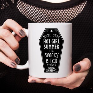 May include: White ceramic mug with a black and white graphic of a coffin with the text "Move Over Hot Girl Summer It's Spooky Bitch Season".
