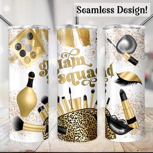 May include: Three stainless steel tumblers with a white background and gold accents. The tumblers feature a makeup theme with images of makeup brushes, lipstick, eyeshadow palettes, and eyelashes. The text "glam squad" is featured on one of the tumblers.