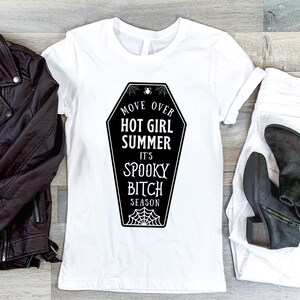 May include: White t-shirt with a black graphic of a coffin that says "Move Over Hot Girl Summer It's Spooky Bitch Season".