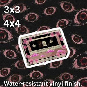 May include: A die-cut sticker featuring a cassette tape decorated with pink cherry blossoms and clouds. The tape is labeled with the text 'UNTIL THE TAPE RUNS OUT ON ME' and 'EVEN IN ARCADIA'. The sticker has a water-resistant vinyl finish.