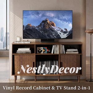 May include: A brown wooden media console featuring two fluted cabinet doors, an open center shelf, and an open top shelf. The unit displays books, vinyl records, and a television screen showing a mountain landscape. Text reads NestlyDecor.