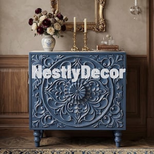 May include: A blue wooden cabinet featuring intricate carved floral and scroll patterns on its two front doors. The cabinet stands on four short, rounded legs and displays the text NestlyDecor across the center of the front panel.