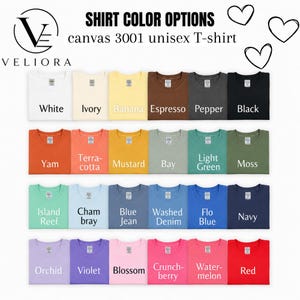 Pu&ograve; includere: Una tabella colori per le t-shirt unisex Canvas 3001 di Veliora, che mostra ventiquattro t-shirt piegate in varie tonalit&agrave;, tra cui bianco, avorio, banana, espresso, pepe, nero, igname, terracotta, senape, baia, verde chiaro, muschio, barriera corallina, chambray, blue jean, denim lavato, blu flo, blu navy, orchidea, viola, fiore, crunchberry, anguria e rosso.