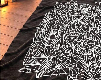 May include: A dark gray blanket featuring a large, intricate white line art design. The pattern consists of abstract geometric shapes, floral-like motifs, and interconnected lines that cover a significant portion of the fabric surface.