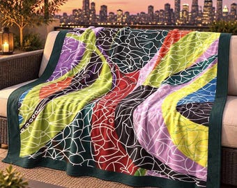 May include: A rectangular throw blanket featuring a vibrant, multi-colored abstract pattern of intersecting white lines over blocks of lime green, deep red, purple, and blue, finished with a solid dark green border along the edges.