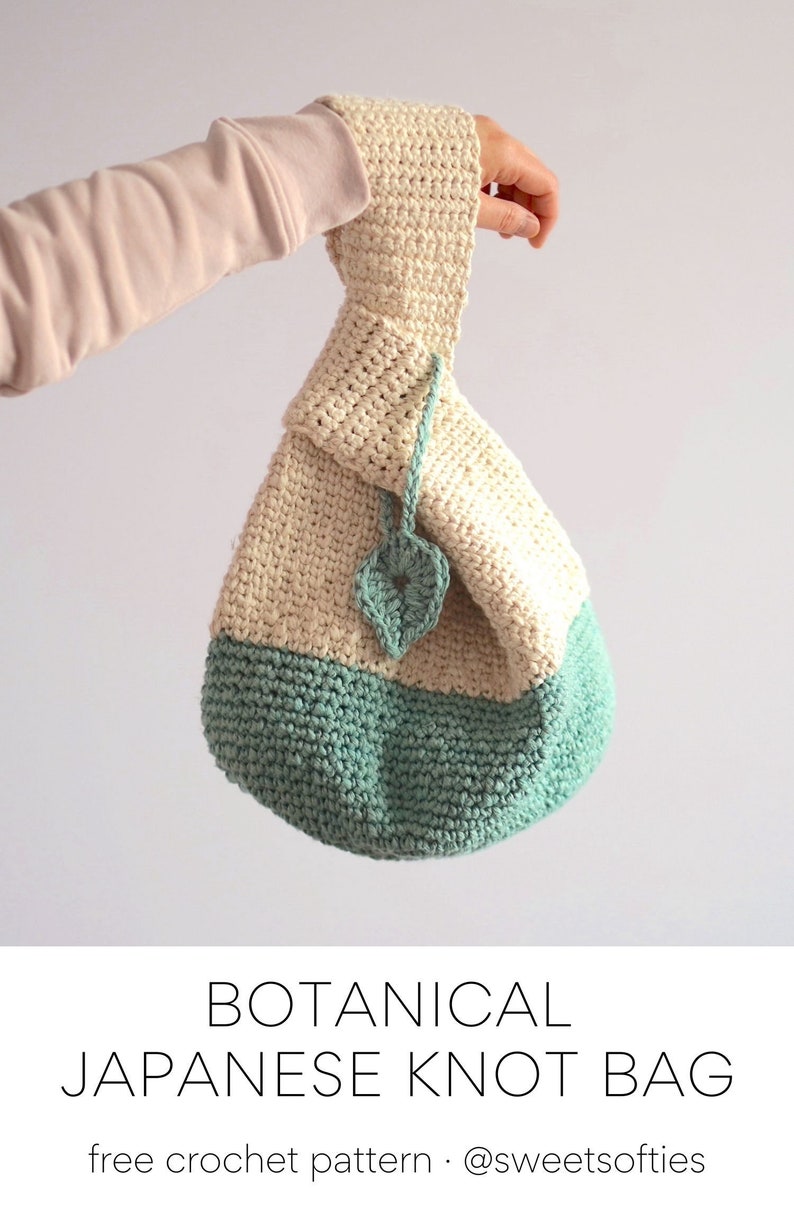 May include: A crocheted bag with a cream top and a teal bottom. The bag has a leaf design on the front and is tied with a cream cord. The bag is held by a hand wearing a light pink sweater. The text "BOTANICAL JAPANESE KNOT BAG" and "free crochet pattern @sweetsofties" is below the image.