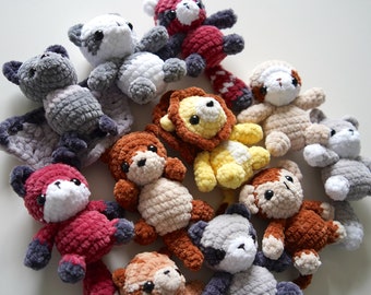 Può includere: Una collezione di animali di peluche all'uncinetto in vari colori e forme di animali, tra cui un leone, una volpe, un orso, una scimmia e un procione. Gli animali sono realizzati con filato morbido e peloso e hanno occhi grandi ed espressivi.